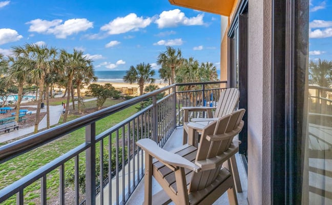 Oceanfront balcony with blue Adirondack chairs overlooking the Atlantic at Myrtle Beach